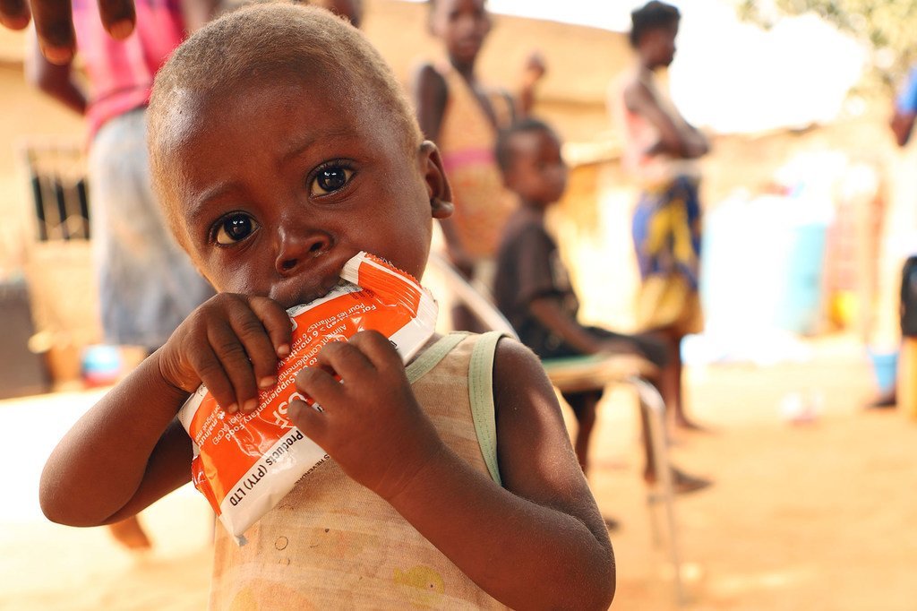 Uma menina de dois anos come pasta nutricional depois de ser identificada com desnutrição em Angola.