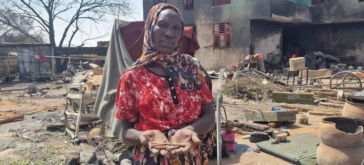 Uma mulher segura cartuchos de armas disparados em combates no oeste de Darfur