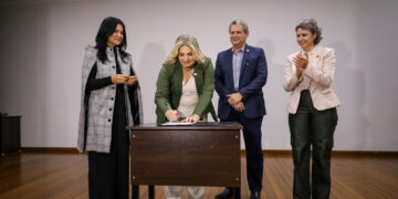 Adriana Palmieri assina documento diante da primeira-dama e presidente do Pra Somar, Bernadete Barros, do prefeito Silvio Barros e da vice-prefeita Sandra Jacovós (Credito: Rafael Macri/PMM)
