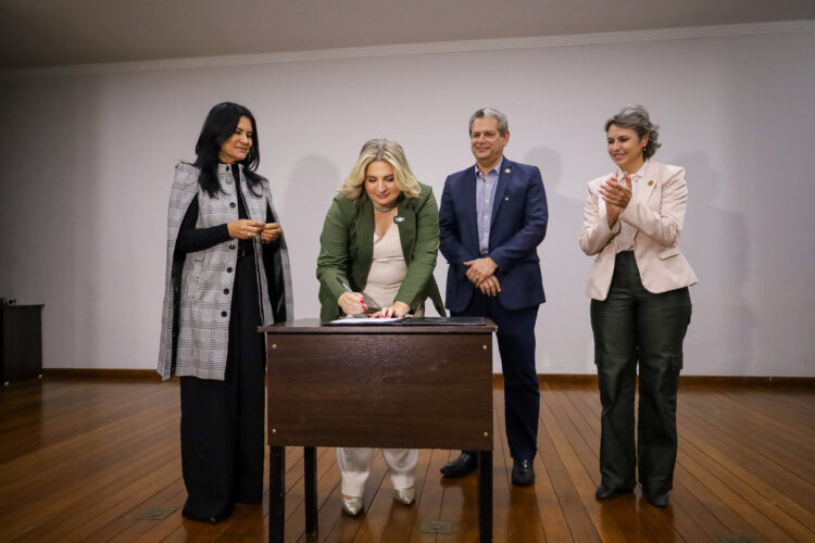 Adriana Palmieri assina documento diante da primeira-dama e presidente do Pra Somar, Bernadete Barros, do prefeito Silvio Barros e da vice-prefeita Sandra Jacovós (Credito: Rafael Macri/PMM)