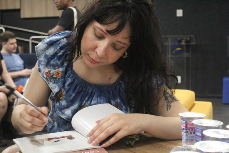 Mia Oliveira autografa volume do Sesc durante lançamento em Maringá (Crédito: Cristiano Martinez)
